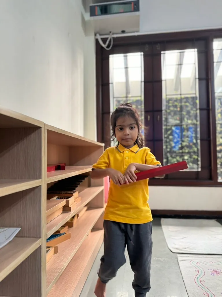 Child choosing work from the shelf, Montessori classroom in Jayanagar
