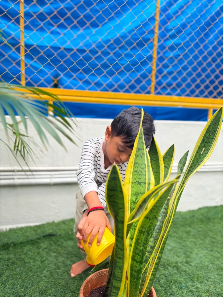 Child watering plants in the garden at ACE Montessori, Jayanagar, Bangalore
